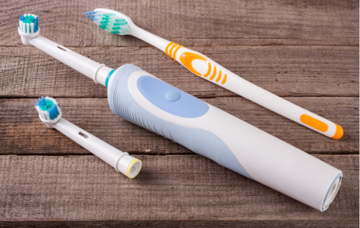 electric and manual toothbrushes side by side