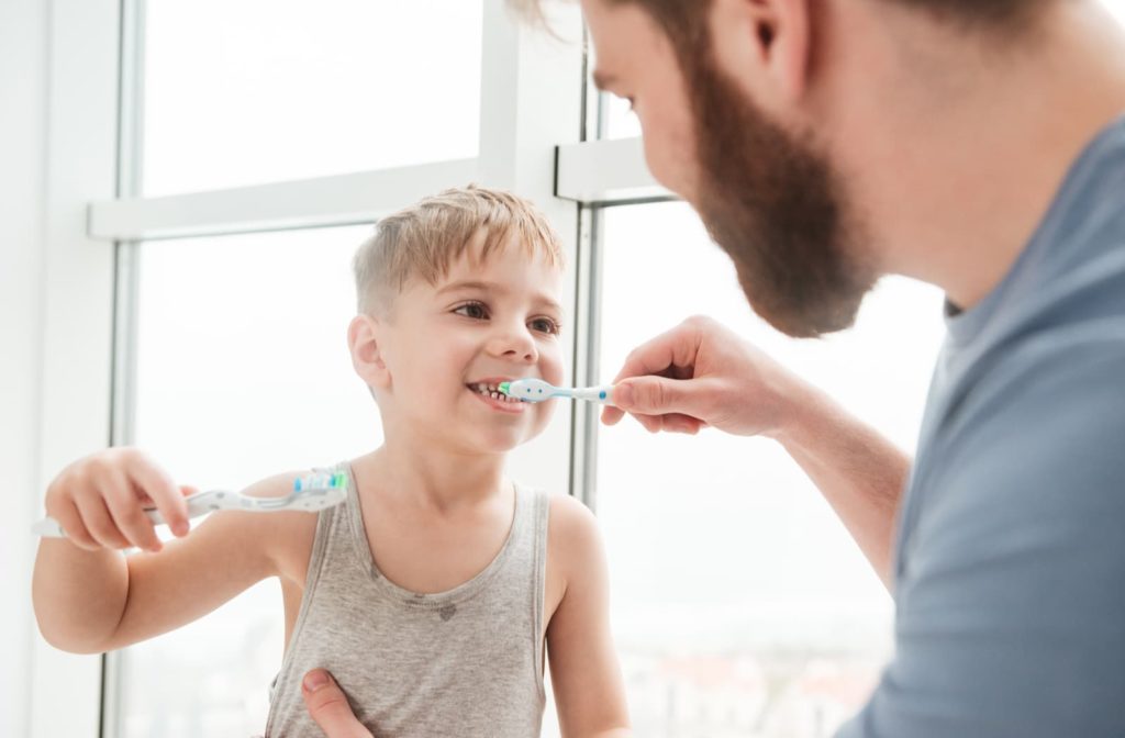 father and son brushing their teeth together