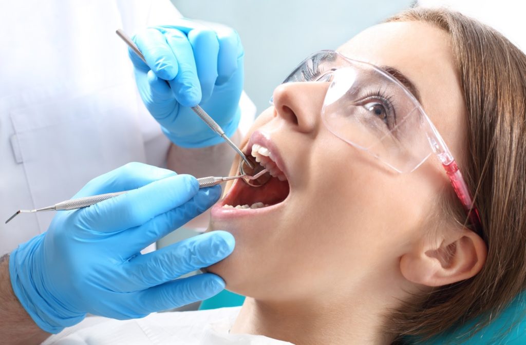 Young woman having her teeth examined after receiving a dental filling