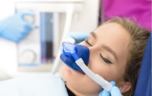 Woman with her eye closed receiving nitrous oxide at a dental clinic