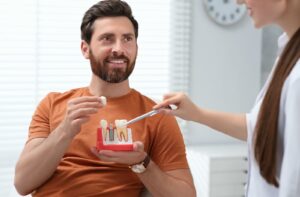 a man is at a consultation with a dental professional discussing dental implants.