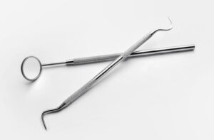 Metal dental tools on a white background.